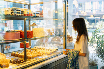 Woman choosing desserts at a bakery display