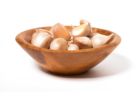 a wooden bowl filled with garlic cloves
