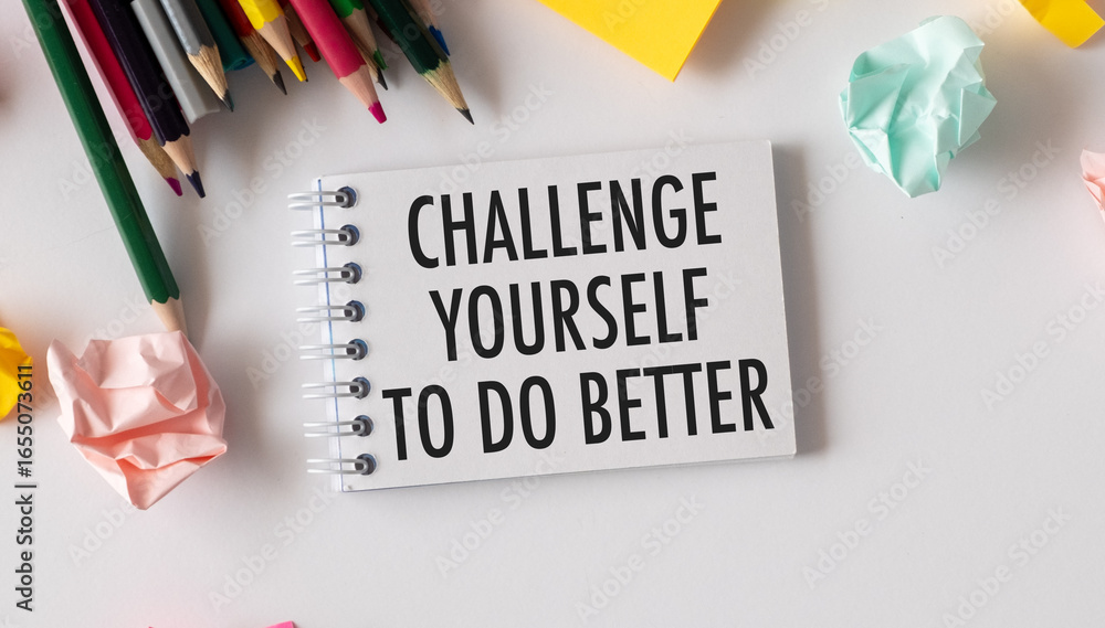 Poster a notebook with the words challenge yourself to do better written on it.