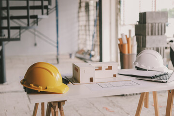 Construction manager and engineer dressed in orange work vests and hard helmets explore...