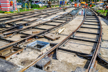 Construction of tram tracks in an urban setting showcasing new rail systems being laid down on a...