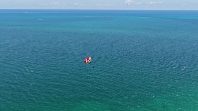 Parasailing sport activity. Parachute in the sky. Extreme rest and parasailing. Summer vacation. Sea sport. Parachute parasail. Water sport on summer vacation. Parasailing recreation with parachute