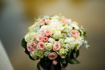 Close-up of a bouquet  roses decorated with greenery and delicate flowers.