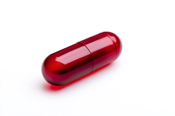 a red pill sitting on top of a white surface