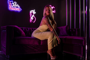 Attractive blonde female wearing a dress in the vip room of a night club