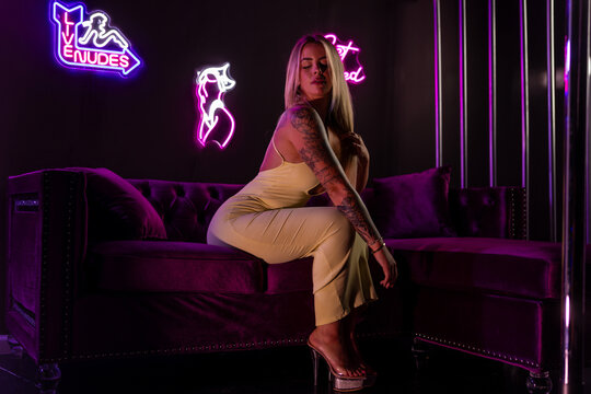 Attractive blonde female wearing a dress in the vip room of a night club