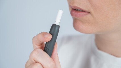 Woman smoking tobacco heating system. Electronic cigarette.