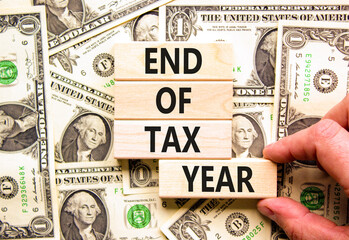 End of tax year symbol. Concept words phrase End of tax year on beautiful wooden blocks. Dollar...