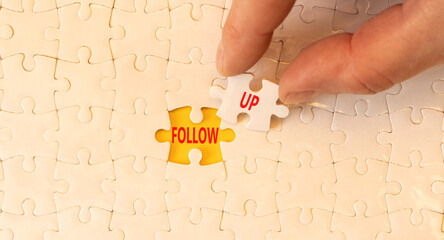 Follow up symbol. Concept word Follow up on beautiful white puzzles. Businessman's hand. Beautiful...