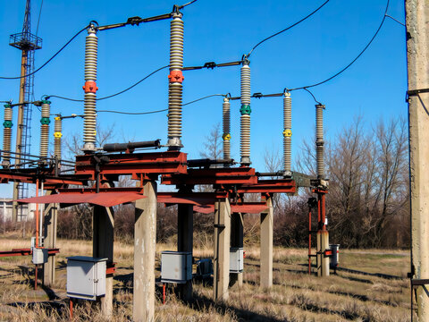 Substation disconnect switches 110 kV. Disconnect switches and insulators on a structure at an electrical power substation on a sunny day.