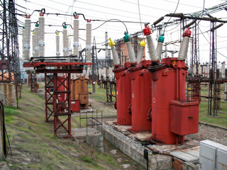 USSR dead tank oil circuit breakers, disconnect switches 110 kV. High-voltage transformers and circuit breakers at an electrical power distribution plant.