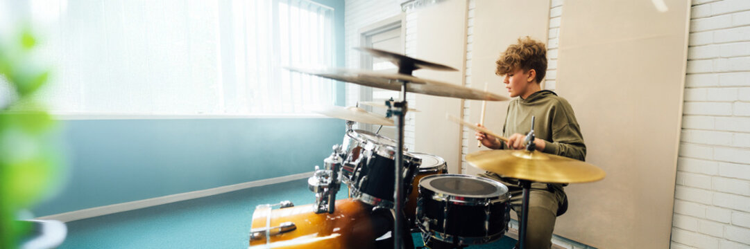 Wide banner of young drummer in rehearsal room - Powered by Adobe