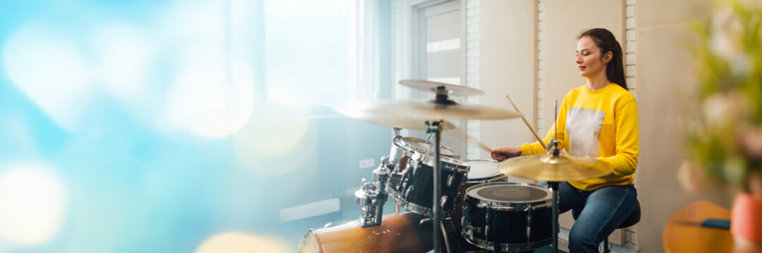 Woman Playing Drums in Studio Wide Banner with Copy Space