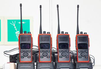 Many walkie-talkies stand in the chargers and charge.