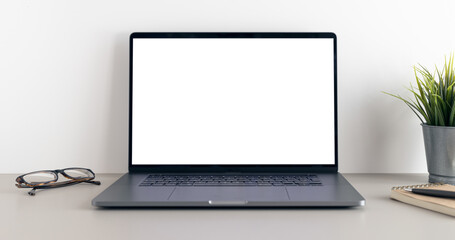 Fototapeta premium Modern laptop with blank white screen on minimalist desk. Mock up template