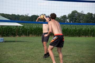 Doubles volleyball player setting the ball while blocker watches the set