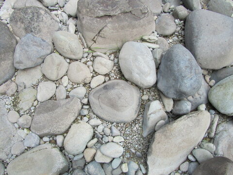 Smooth, waterworn river rocks and pepples on Oregon riverbed, riverbank artfully arranged by nature