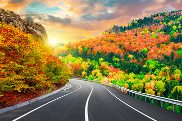 autumn road landscape in beautiful nature travel. autumn colors in mountain road scenery. autumn landscape on the highway in colorful forest. nature trip in fall. highway landscape on fall season.
