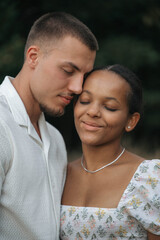 Obraz premium Affectionate moment of an interracial couple, close-up portrait of love, joy and authentic emotions.