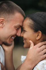 Affectionate moment of an interracial couple, close-up portrait of love, joy and authentic emotions.