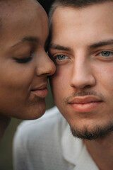 Obraz premium Affectionate moment of an interracial couple, close-up portrait of love, joy and authentic emotions.