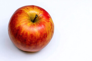 a red apple with a green stem on a white surface