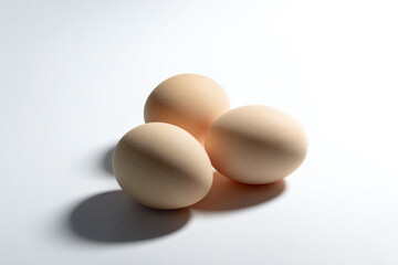 three eggs are sitting on a white surface