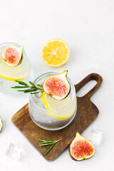  Lemon cocktails with fig and rosemary on wooden board