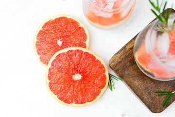 Grapefruit cocktail with rosemary and ice showing citrus slices and sparkling liquid