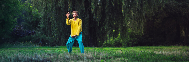 Man practicing tai chi in nature wide banner with copy space