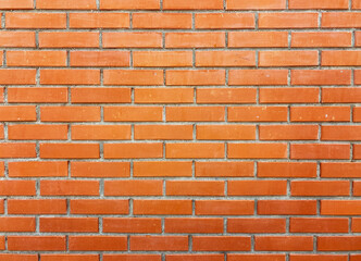 Orange brick wall texture with cement straight seam lines. Rectangular bricks. Background closeup.