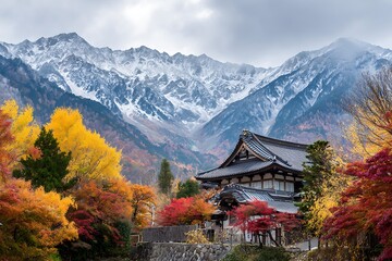 Fototapeta premium Japanese temple nestled in autumn colors with majestic snow capped mountains