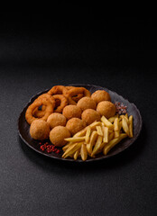 Fast food, cheese balls, onion or squid rings and French fries. Junk food as a background