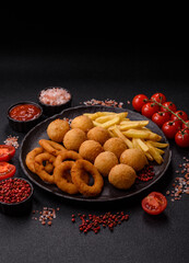 Fast food, cheese balls, onion or squid rings and French fries. Junk food as a background