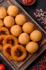 Fast food, cheese balls, onion or squid rings and French fries. Junk food as a background