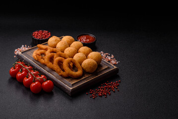 Fast food, cheese balls, onion or squid rings and French fries. Junk food as a background