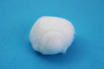 Soft white cotton ball on a blue background