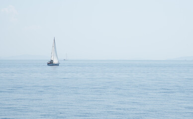 Fototapeta premium Sailboat with mast and open sails is sailing on a calm sea. Greek Islands, Ionian Sea