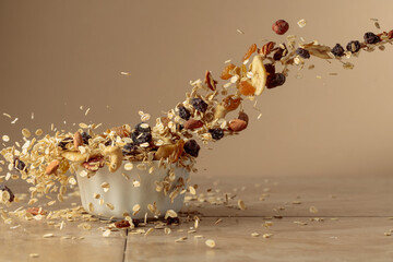 Muesli in motion on a beige background.