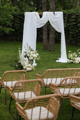 Outdoor wedding ceremony arch with white drapery