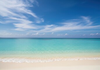 Obraz premium Crystal clear turquoise ocean water meets a white sandy beach under a bright blue sky with scattered clouds, a tropical paradise scene