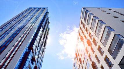 Exterior of a high modern multi-story apartment building - facade, windows and balconies. Timeless glass facade. Modern urban living district.
