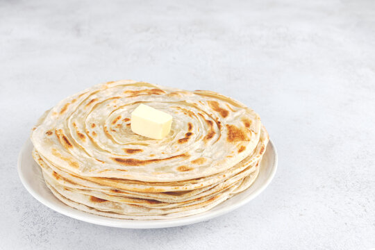Traditional Indian paratha with butter on white background. Indian food.