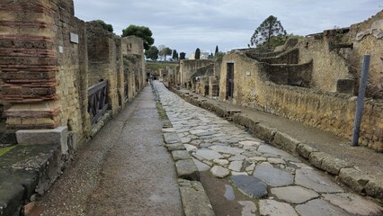 Herculaneum, Italy - 9 January 2025. A preserved Roman road lined with weathered structures and...