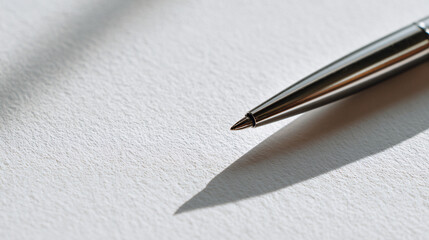 close-up of plain white paper with sleek metal pen laid diagonally, seamless neutral background, clean minimalist professional style