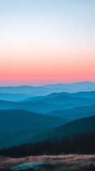 Fototapeta premium Landscape view of blue and pink mountains at sunrise, soft morning light illuminating peaks, serene natural scenery ideal for travel, inspiration, and scenic visual projects.