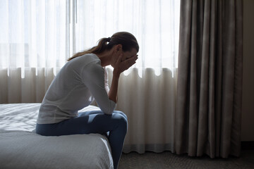  Portrait of crying depressed young woman in bedroom. fear, sadness, abuse, depression, addiction