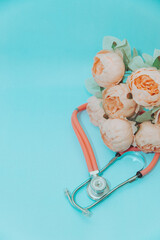 Medical Instruments with flowers on blue Background. photo of a medical hammer, orchidometer,...