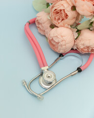 Medical Instruments with flowers on blue Background. photo of a medical hammer, orchidometer,...