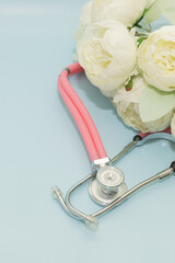 Medical Instruments with flowers on blue Background. photo of a medical hammer, orchidometer,...